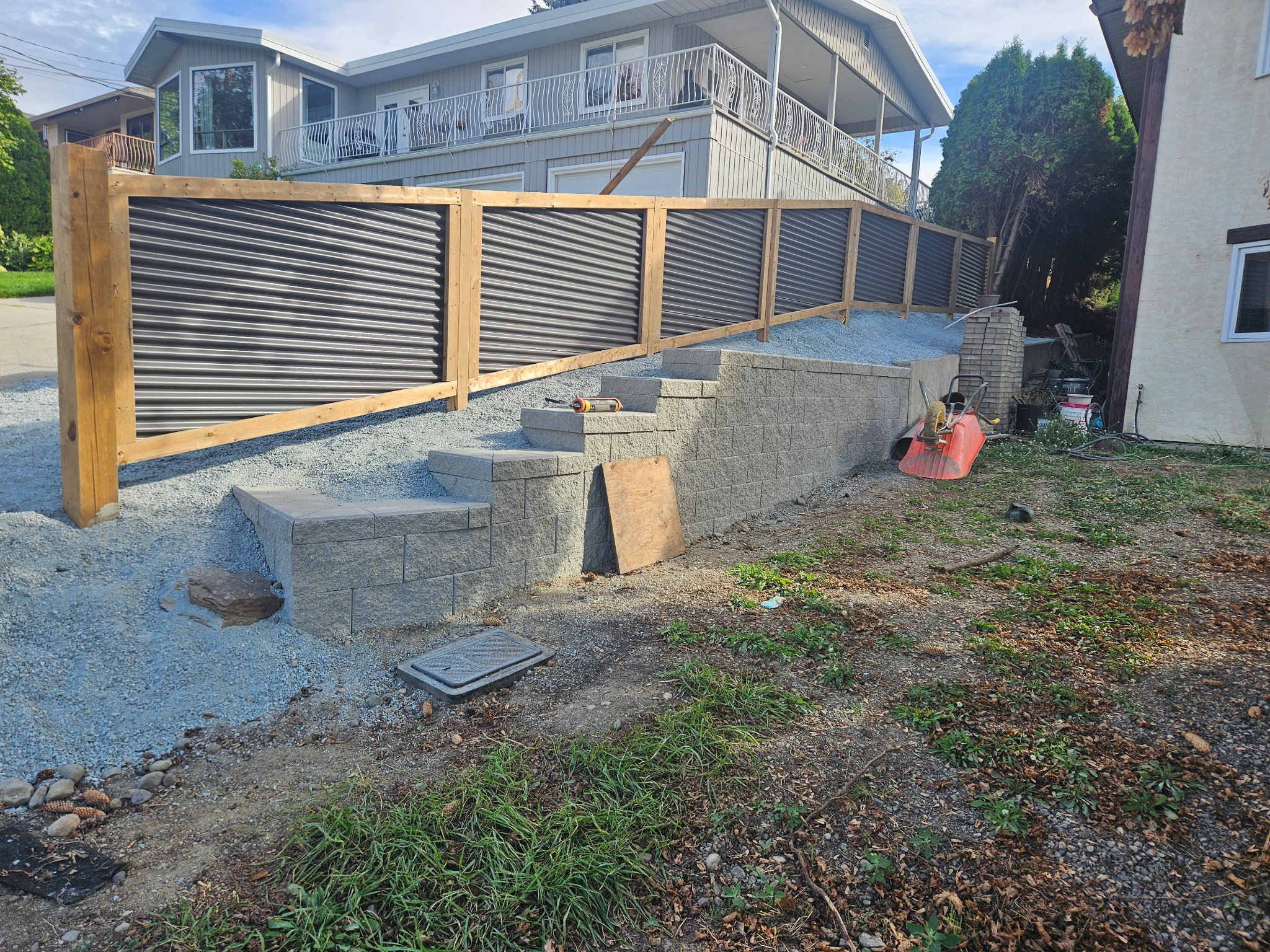 Fence line running above a block retaining wall with steps