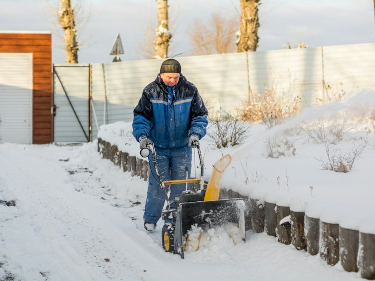 Clearing a residential driveway with a snow blower after an Okanagan snowfall